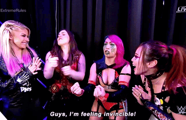 a group of female wrestlers are standing together and one of them is saying guys i 'm feeling invincible