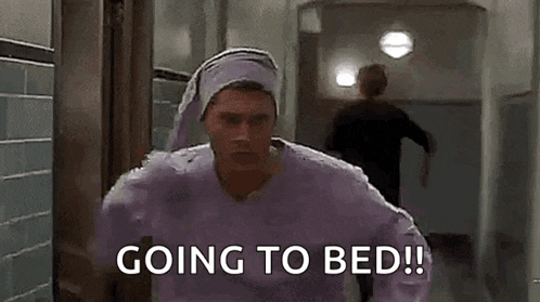 a man wearing a purple shirt and a purple hat is running to bed .