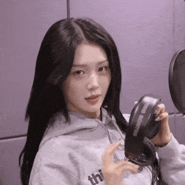 a woman holding a pair of headphones with the word headphone on them