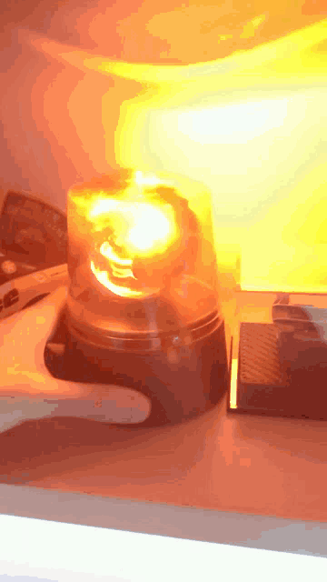 a hand is pressing a button on a beacon that is lit up