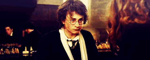 harry potter wearing glasses and a scarf looks at the camera