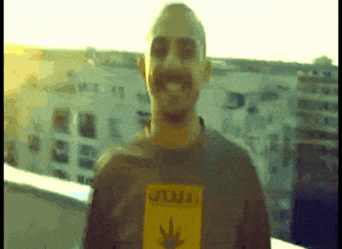 a man wearing a jamaican shirt stands in front of buildings