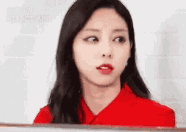 a woman in a red shirt is making a funny face