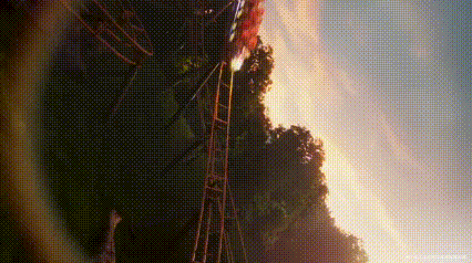 a roller coaster ride is going down a hill at sunset