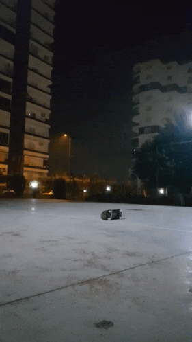 a skateboard is laying on the ground in front of a tall building