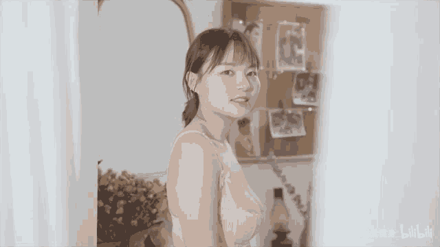 a young woman in a bra is standing in front of a mirror .