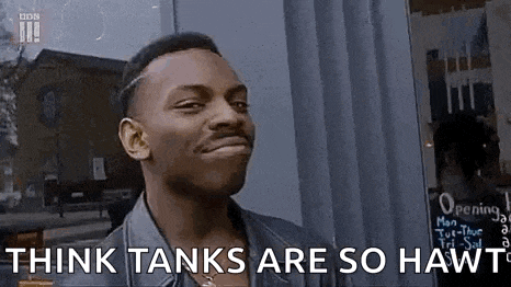 a man is making a funny face and saying `` think tanks are so hawt '' in front of a window .