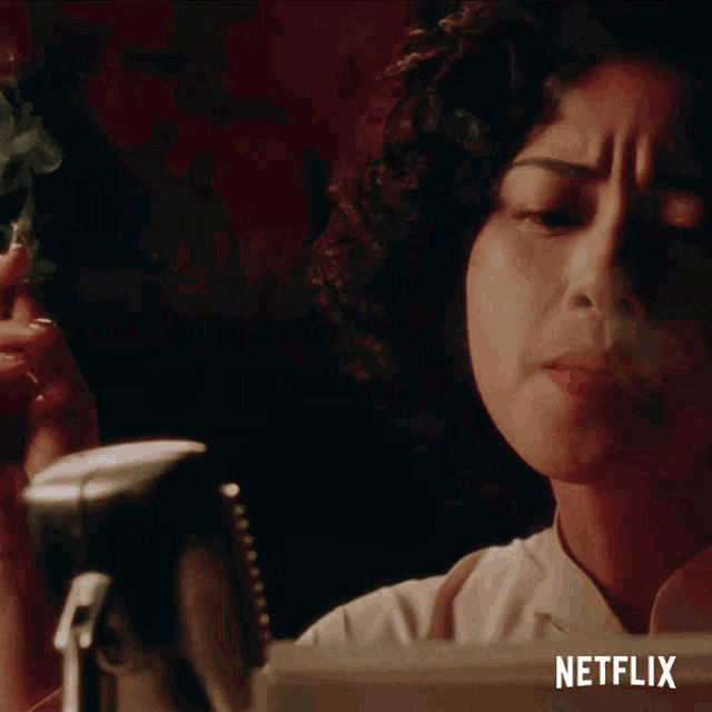 a woman smoking a cigarette next to a microphone with netflix written on the bottom