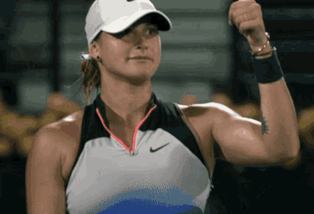 a woman with a tattoo on her arm is wearing a white nike hat