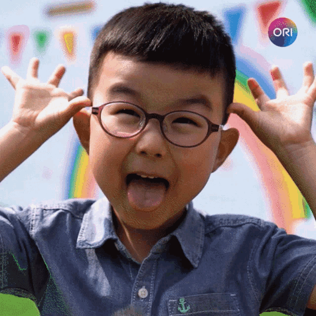 a young boy wearing glasses making a funny face with ori written in the corner