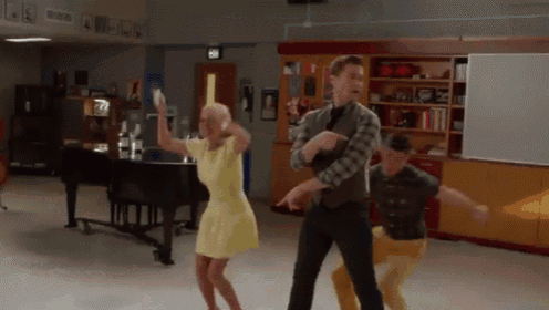 a group of people are dancing in a room with a piano and a sign that says exit