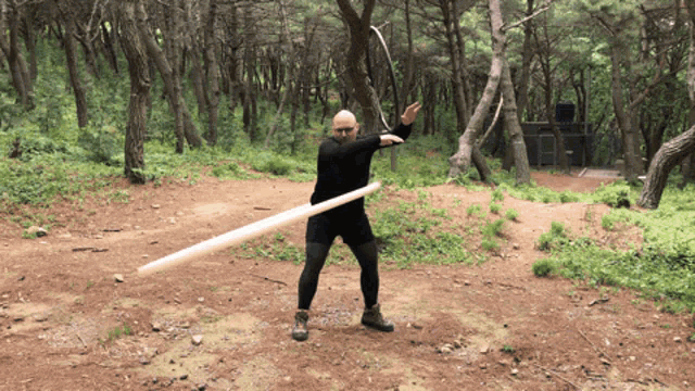 a man in a black shirt is throwing a spear in the air
