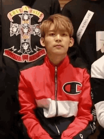 a young man is wearing a red champion jacket and a guns n roses sweatshirt .