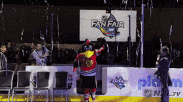a mascot is standing in front of a sign that says fan fair