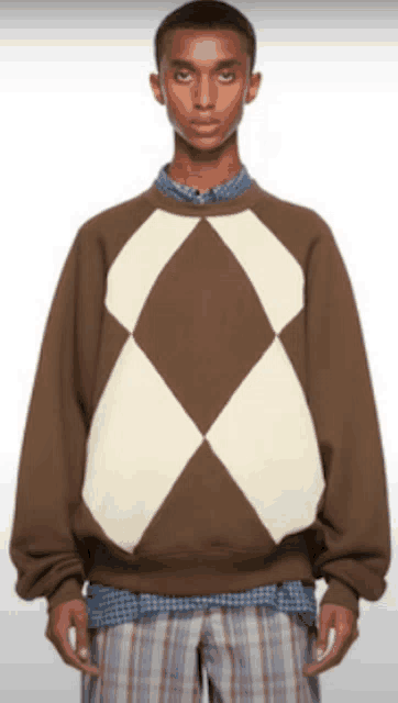 a man wearing a brown and white sweater with diamonds on it