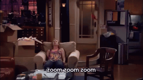 a woman is sitting in a chair in a living room with the words zoom zoom zoom below her