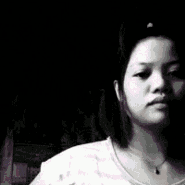 a black and white photo of a woman wearing sunglasses and a necklace