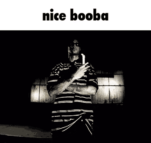 a man in a striped shirt is holding a gun in his hand and the words nice booba are above him .