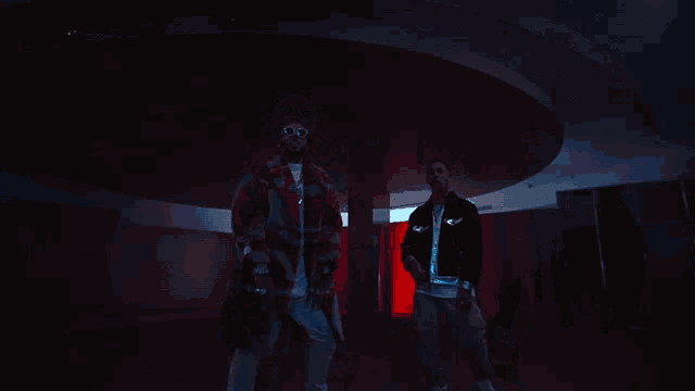 two men standing next to each other with one wearing a coat that says supreme