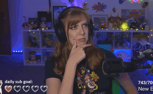 a woman wearing headphones is sitting in front of a microphone with a daily sub goal of 743/70