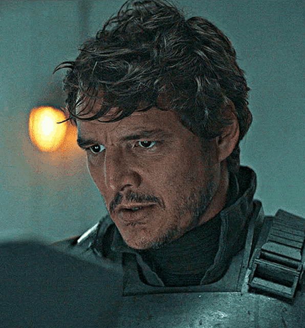 a close up of a man with a beard wearing armor and a turtleneck .