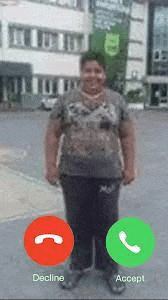a fat man is standing in front of a building while talking on a cell phone .