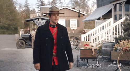 a man in a military uniform is standing in front of a building that says hallmark on it