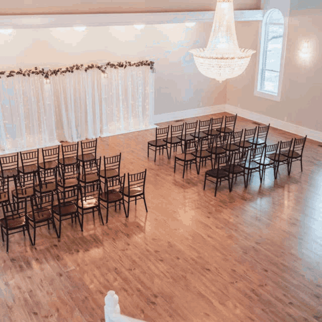 rows of chairs are lined up in a room with a chandelier hanging from the ceiling