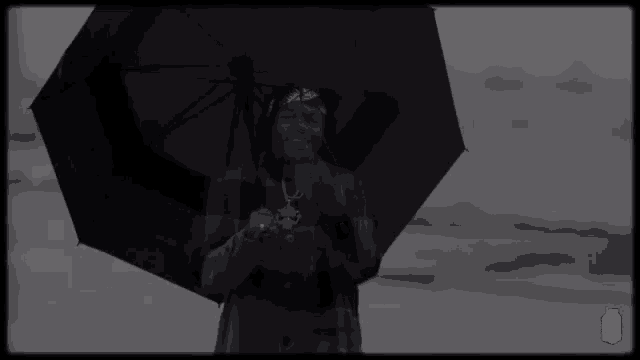 a black and white photo of a person holding an umbrella with a lychee box in the corner