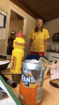 a can of fanta sits on a table in front of a woman