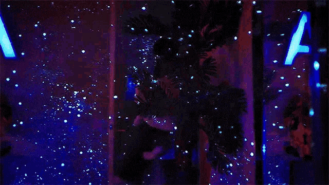 a person is standing in front of a glow in the dark sign that says a on it .