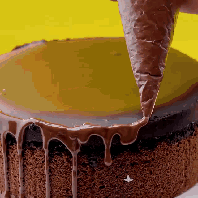 a cake is being decorated with chocolate frosting