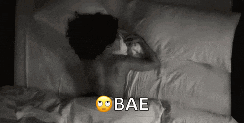a black and white photo of a woman laying on a bed with the words bae written on the bottom