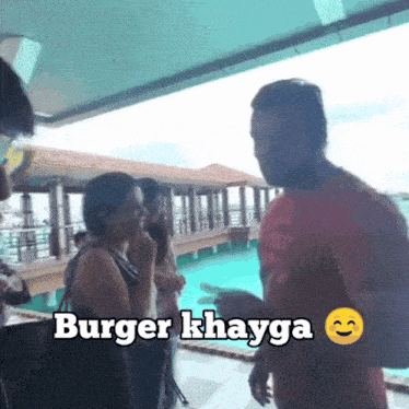 a group of people standing in front of a swimming pool and a sign that says burger khayga