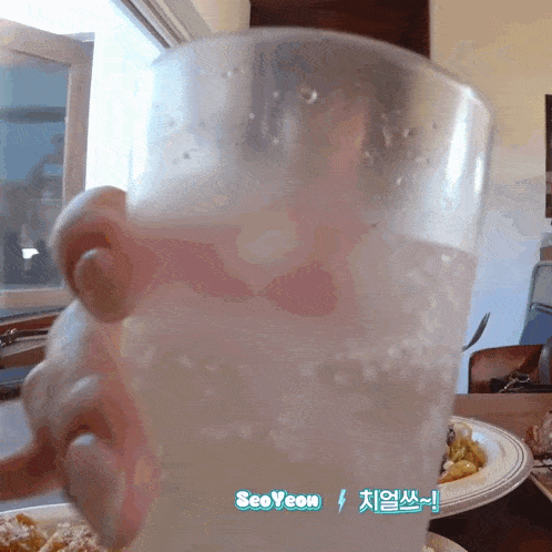 a person is holding a glass of water with the name seoyeon written on the bottom