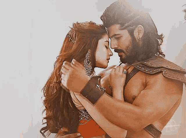a man and a woman are hugging and looking into each others eyes