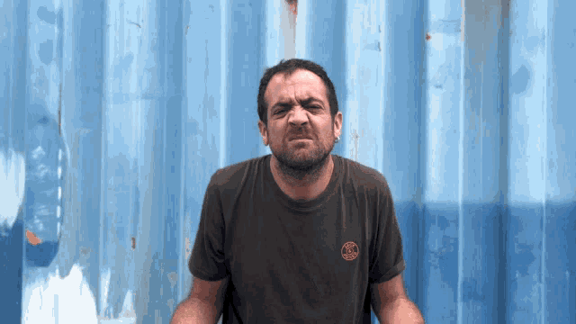 a man wearing a t-shirt with a circle on the front making a funny face