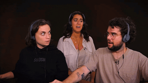 three people wearing headphones one of whom is wearing a black shirt that says swoosh