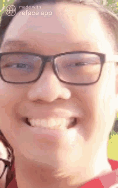 a man wearing glasses is smiling for the camera .