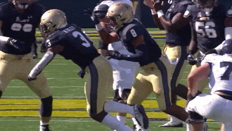 a football player with the number 3 on his jersey is being tackled by another player