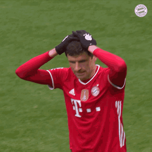 a soccer player wearing a red shirt that says ' bayern munchen ' on it