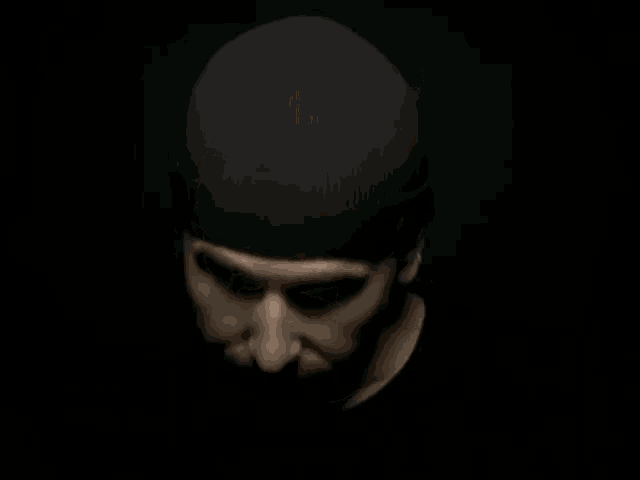 a man with a beard is wearing a black hat .