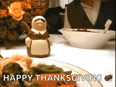 a person is sitting at a table with a plate of food and a bowl of cereal and says happy thanksgiving .