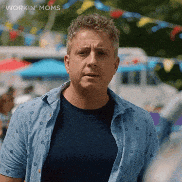 a man in a blue shirt is standing in front of a crowd with the words workin ' moms written on the bottom