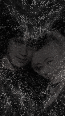 a black and white photo of a man and woman surrounded by glitter