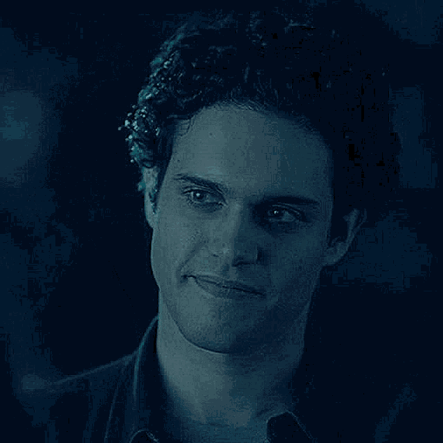 a close up of a man 's face in a dark room .