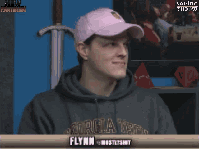 a man wearing a pink hat and a hoodie with the name flymm on the front