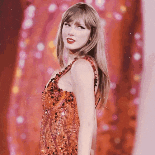 a woman in a red sequined dress is standing in front of a pink background