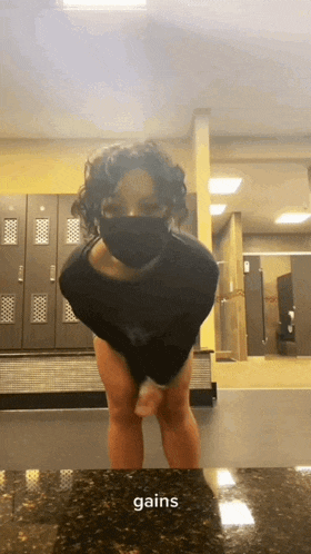 a person wearing a mask is standing in front of lockers and the word gains is on the counter