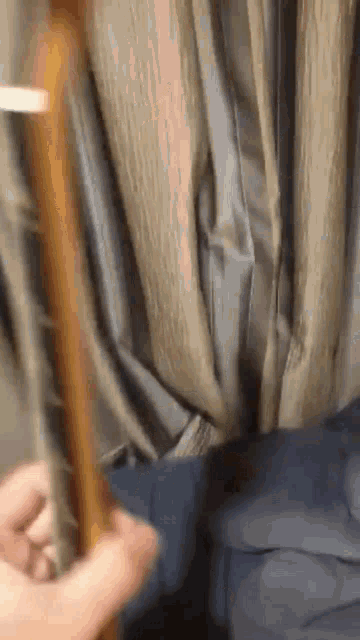 a person playing a guitar in front of a curtain